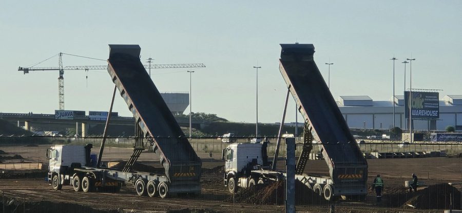 Two tipper trucks unloading on a construction site